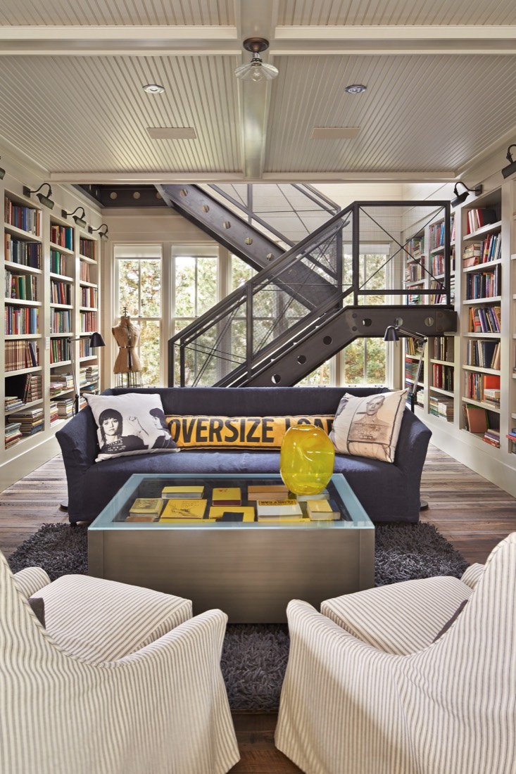Library with floor-to-ceiling shelving and a stair